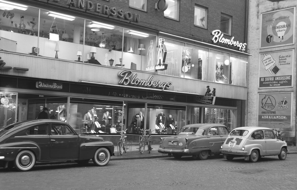 Reklamfoto av Ateljé Eggeborn. I bild syns även Restaurang Smedjan och reklamaffischer för Sigfrid Anderssons elektriska affär och Abahamsons fröhandel.
