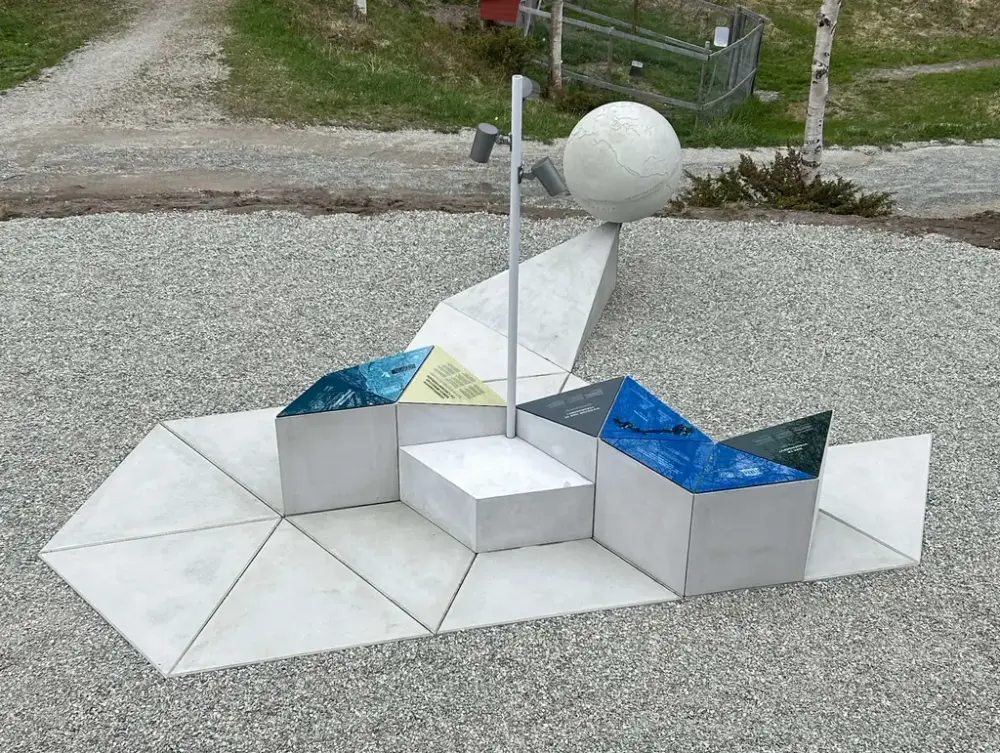 oversiktsbilde av utstillingen Vår verdensarv. utendørs på grus. steinblokker som er plassert oppå hverandre