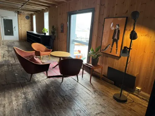 Her ser vi en sofagruppe i det flotte lokalet i Sandviksboder 24, med utsikt mot havnen utenfo