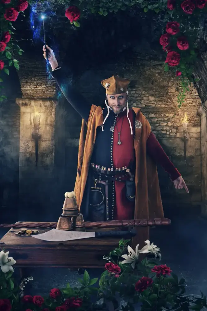 Magiker med tryllestav i rød og blå cotehardie med oransje kappe og oransje hatt