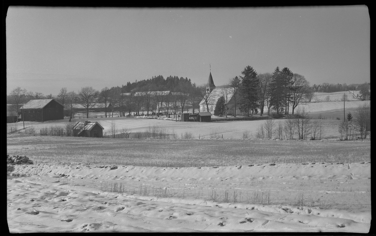 Bälinge kyrka fotograferad med snöiga åkrar runt om.