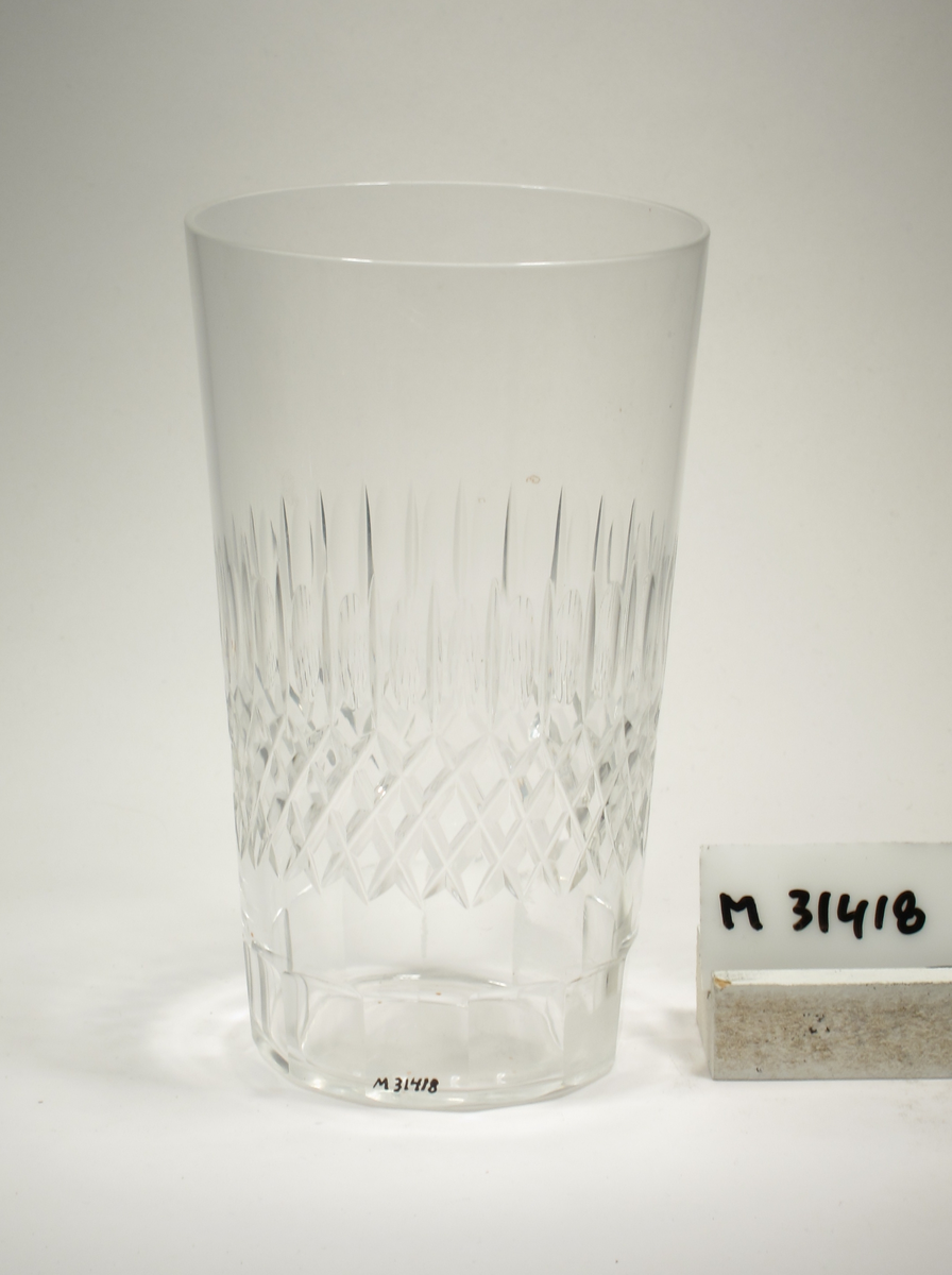 Konande kupa med fasettslipat längst ner. På mitten rutslipning samt en rad av omväxlande slipade oliver och skär.