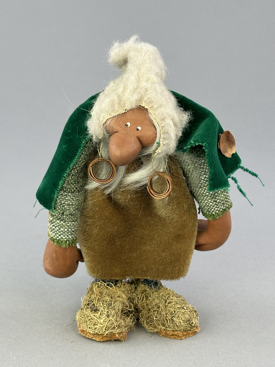 Trollgumma med stora fötter och händer. Är klädd i sammets kjol och sammets cape prydd med kott-blad.