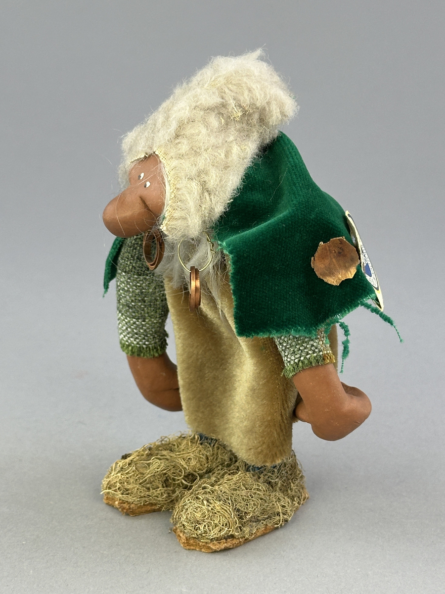 Trollgumma med stora fötter och händer. Är klädd i sammets kjol och sammets cape prydd med kott-blad.