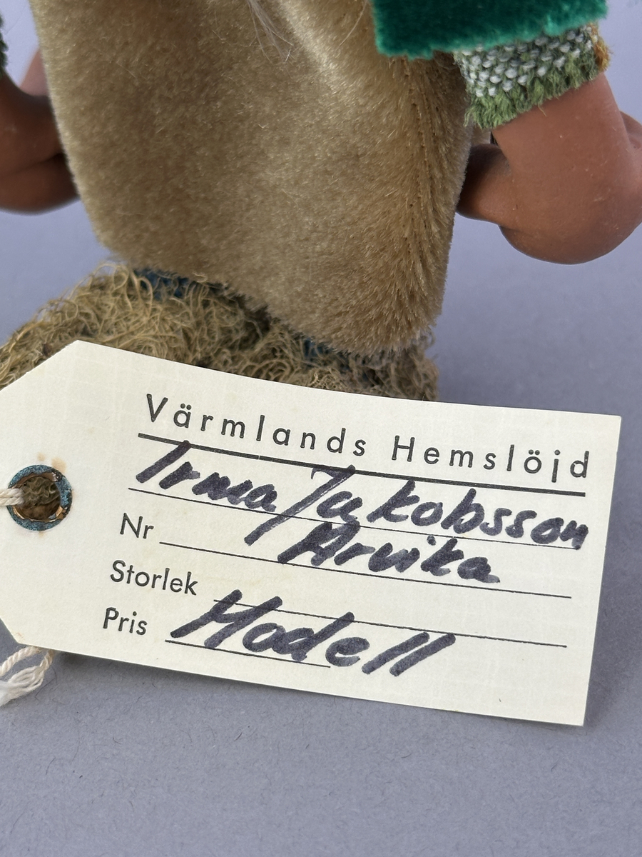 Trollgumma med stora fötter och händer. Är klädd i sammets kjol och sammets cape prydd med kott-blad.