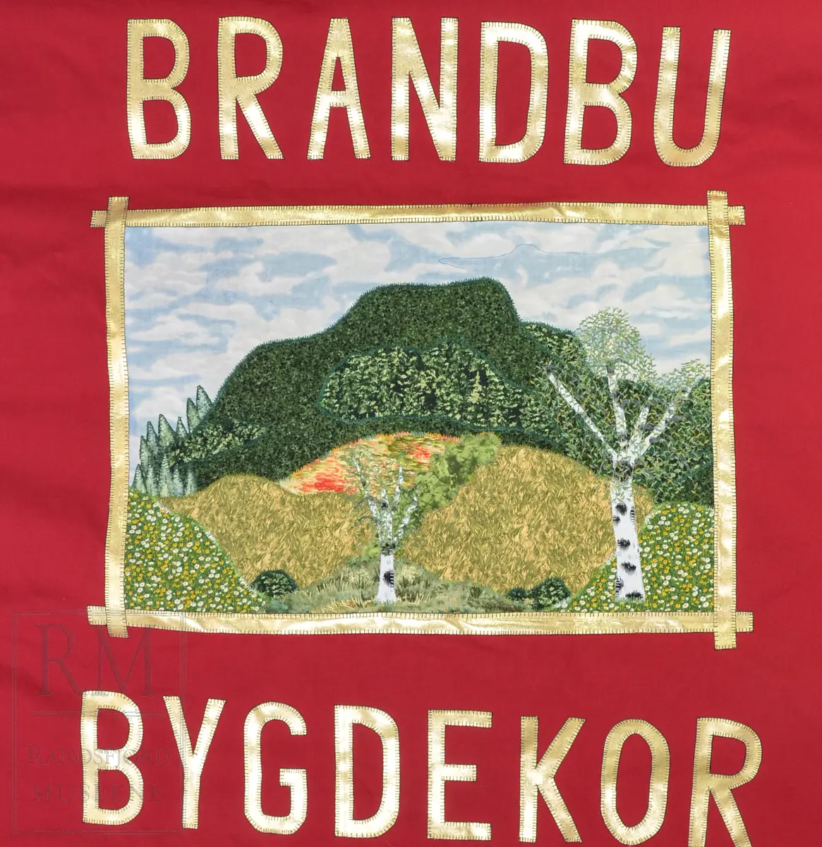 Rød bomullsfane med quiltet motiv
a: fane
b: stangpryd (harpe i messing)
c: bardunsnor m dusker
d: styresnor med håndgrep
e-g: stang og oppheng (e) i alu og messing
h: hvit lærsele
i: bæreveske/ oppbevaringspose i grått kunstskinn