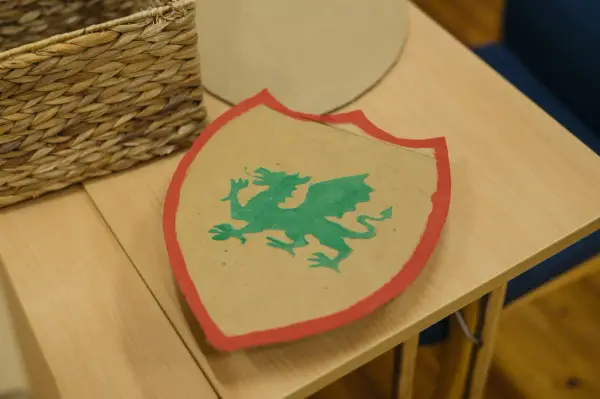 Viser et skjold med rød kant, i midten er det en grønn drage på fire ben.