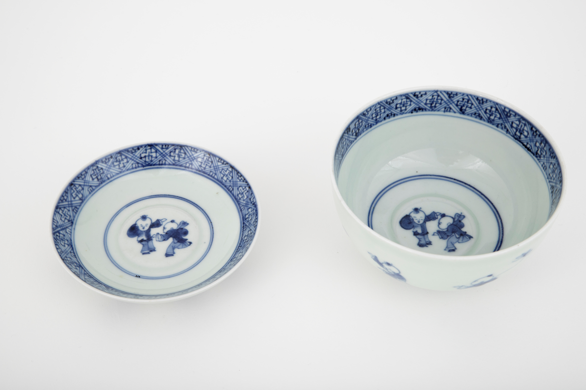 Porselensbolle med lokk med opphøyet midtparti i bunnen av bollen og lokket. Lokket har en diameter som er mindre enn bollens åpning slik at den plasserer seg ca. 1 cm ned i bollen. Lokkets håndtak er utformet som en fotring og kan derfor snus og fungere som en lav skål. Dekket med en hvit glasur og dekorert med en koboltblå underglasur. Bollens og lokkets utside er dekorert med et motiv som forestiller sju lekende barn. På innsiden er de dekorert med et motiv som forestiller to lekende barn samt en geometrisk bord langs kanten.