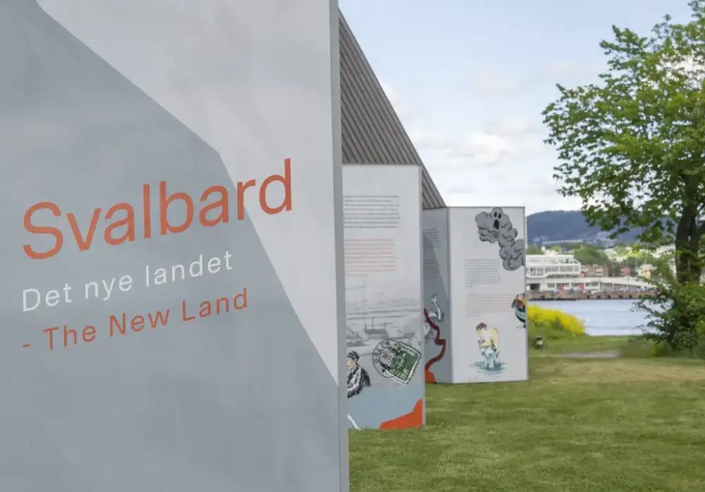  Informasjonssøyler med tekst og illustrasjoner står på gresset utenfor Norsk Maritimt Museum. Nærmest vises en søyle med teksten «Svalbard – Det nye landet».