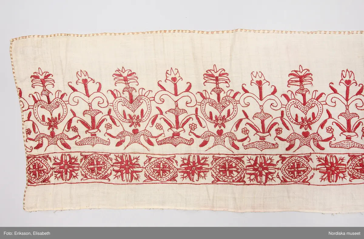 a. komplett lakan med broderad bård.
b. lakan samt lös bård i samma mönster

Mycket fint och tunt tuskaftat linne, broderad bård med stramt stiliserade blommor i renässansstil sydda med mörkt rött tvinnat silke, konturer i stjälksöm med vissa blad fyllda med plattsöm andra med prickar med små stygn. I kanten langetterad bård i gult silke med langettstygnen i grupper så att bården ser rutig ut. Ovanför bården märkt med adliga vapnen för ätten Stake och Posse samt initialerna ES och IP = Erik Olofsson Stake död 1598 gift 1588 med Ingeborg Posse.

Lös bård som hör till lakan b. Samma broderi som på lakan a.
/Berit Eldvik 2008-03-04