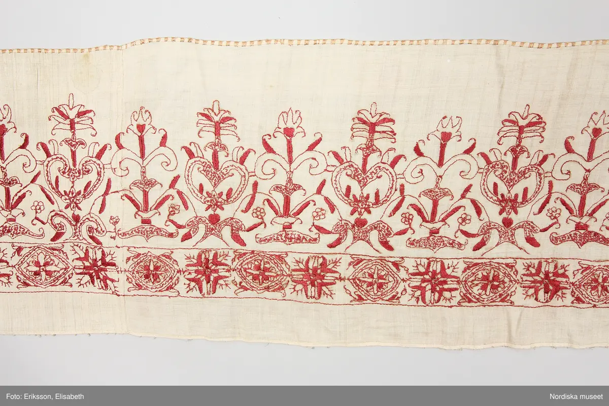 a. komplett lakan med broderad bård.
b. lakan samt lös bård i samma mönster

Mycket fint och tunt tuskaftat linne, broderad bård med stramt stiliserade blommor i renässansstil sydda med mörkt rött tvinnat silke, konturer i stjälksöm med vissa blad fyllda med plattsöm andra med prickar med små stygn. I kanten langetterad bård i gult silke med langettstygnen i grupper så att bården ser rutig ut. Ovanför bården märkt med adliga vapnen för ätten Stake och Posse samt initialerna ES och IP = Erik Olofsson Stake död 1598 gift 1588 med Ingeborg Posse.

Lös bård som hör till lakan b. Samma broderi som på lakan a.
/Berit Eldvik 2008-03-04