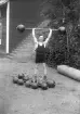 Kraftkarl ifrån atletklubben Heros poserar lyftandes en viktstång med klotvikter, tidigt 1900-tal.