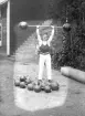 Kraftkarl ifrån atletklubben Heros utför ett tyngdlyft med vikstång, tidigt 1900-tal.