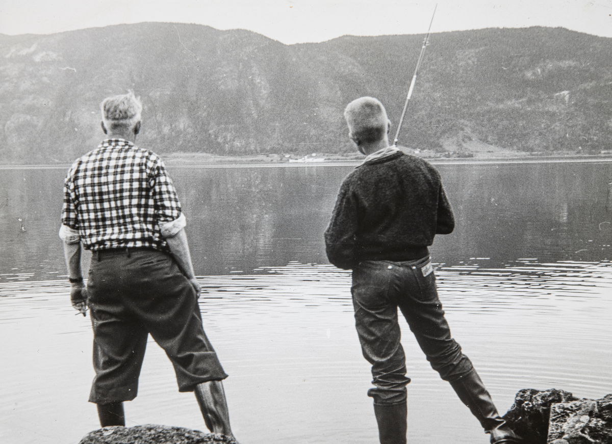 Magnus Gundersen (i rutete skjorte) og Terje Monsen. Stangfiske. Skreia og Skibladner i bakgrunnen. Sted: Espa, 1960-tallet.