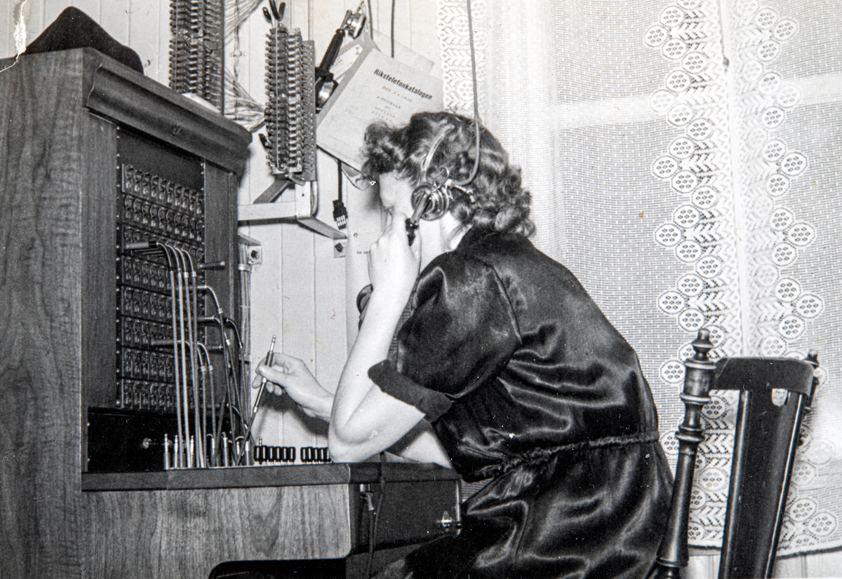 Inger Løvstad (gift Gundersen) på telefonsentralen, Løvstad på Espa. Sentralen ble lagt ned i 1953 og bildet er trolig tatt i den forbindelse.
