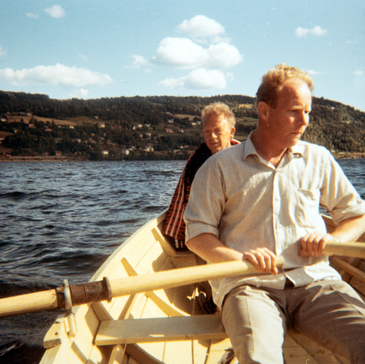 Olav Kristoffer Hagene ved årene og Olav Løvstad. Mjøsa, med Espa i bakgrunnen. Ca. 1970. Robåt på Mjøsa.