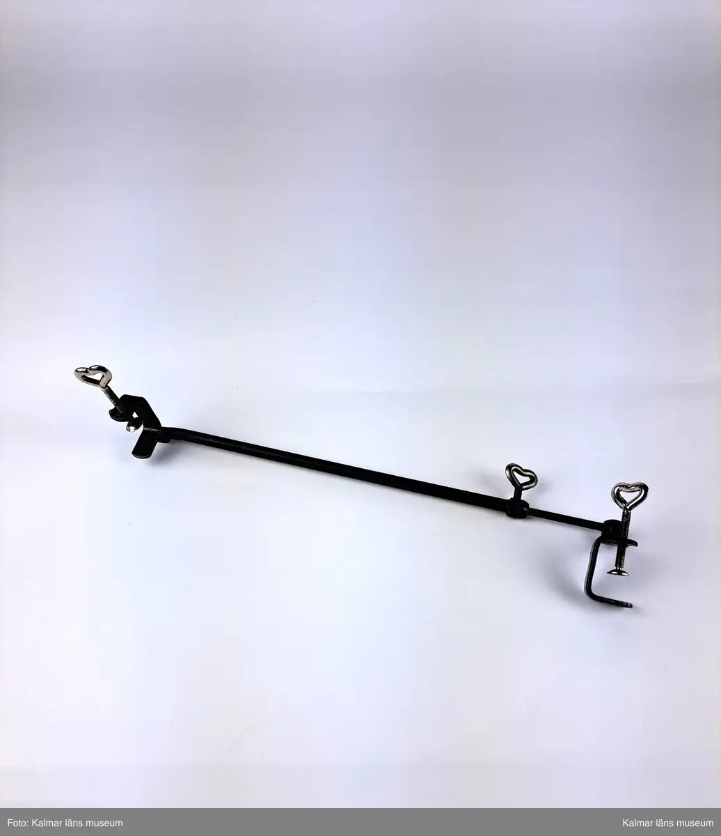 KLM 46734:1. Staffli. Golvstaffli av trä med tre ben, kedja och skruvstöd av metall. Rem av textil  på bakre benet, används i hopfällt läge. På baksidan tillverkarmärke av mässing med text: Beckers MADE IN SWEDEN. I kedjan hänger ett runt företagsmärke av metall och papper med text: A.B. WILH. BECKER KONSTNÄRSMATERIAL. Löst skruvstöd, del till staffli.