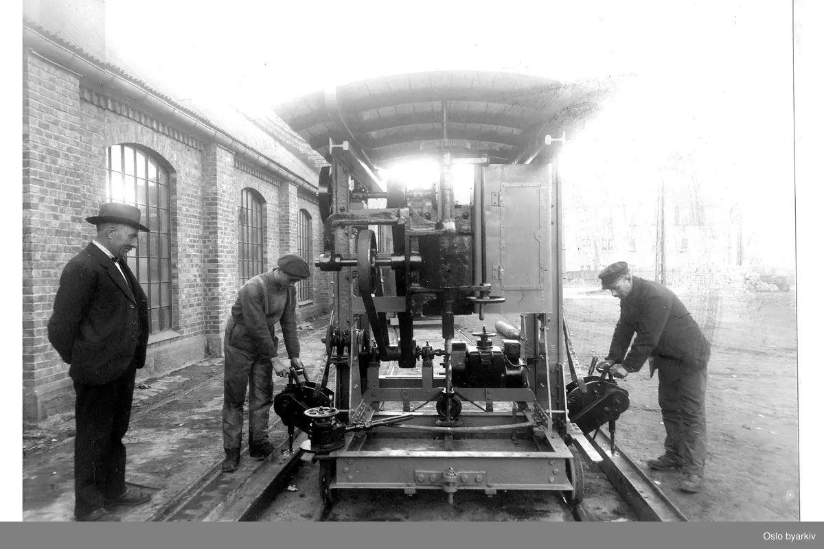 Arbeider med arbeidsvogn utenfor vognhallen på Sagene