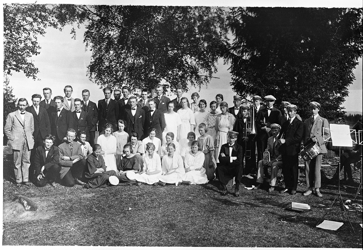 Gruppebilde, muligens fra sang- og musikkstevne på Bruflat, Vestre Toten, 1923-1924. Deltakere var: Aas Korforening, Nedgard Sangkor, Musikkforening fra Eina (?), dirigent Marcus Hermanrud. Noen personer er identifisert (noe uklart beskrevet):
Sittende fra venstre: Nr. 2 Syver M. Ødegård. 
Damer stående i midten: Solveig Gjørvad, Karen Kværnum, Bertha Kluften, Mathea Roterud, ukjent.
Damer stående på kne: Dagmar Aas, Signe Sveen (Amlie), Mary Baggerud, ukjent, Gunhild Aas Espeseth, Olga Hegsum, 2x ukjent.
Sittende foran: Karen Fremstad (Sivesind), Hjørdis Neumann, Nora (etternavn ukjent).
Stående fra venstre: 3.Hans Fremstad, 4.Oscar Fjeld, 5.Samuel Sangnæs, 6.Sverre Solberg, 7.Kristian Fremstad, 11.Hans Fjell, 12.Arthur Aas, 14.Herbjørg Baggerud, 17.Olga Hermanrud. Asta Roterud Nr.2 fra venstre)?, Sigurd Huset (høyre)?
Musikere fra venstre: Odvin Olsen, Petter Blåvarp, Hjalmar Storhaugen 3x ukjent?, Erling Blåvarp. Sittende: O.C.Blåvarp, Else (?) Hermanrud (fornavn usikket).
Tillegg: Første rekke nr. 3: Alm, Sig. Nr.2 (?) Johanne Molstad.