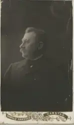 Portrett i halvprofil av mann med mustasje. Johan Dahl Kristensen (1859-1918) fra Mjelde på Engeløya i Steigen. Han flyttet siden til Harstad der han og hans kone Anna Kornelia fikk 17 barn.