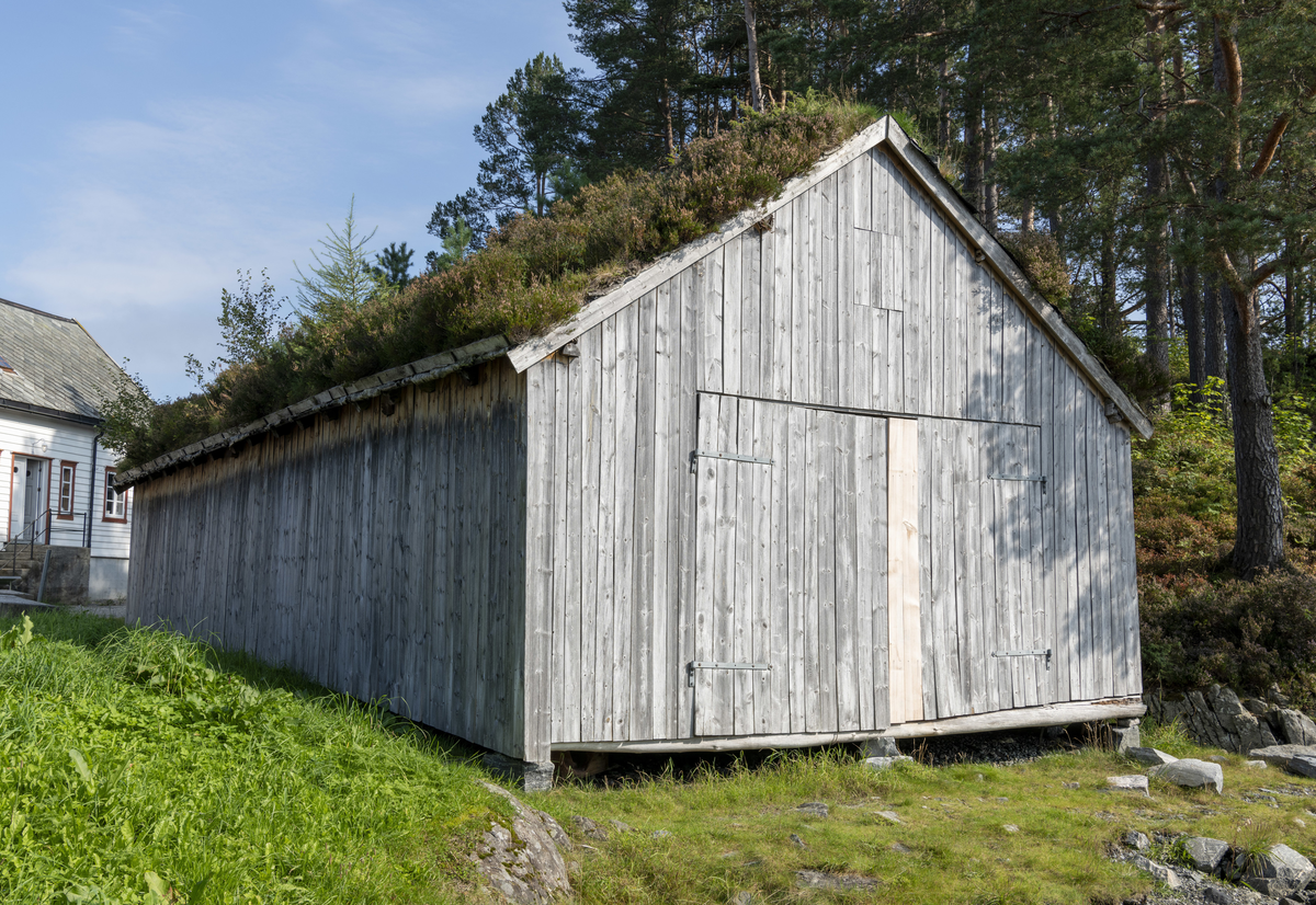 Grindbygg med ståande låvepanel og torvtak.