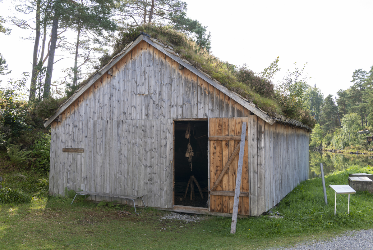 Grindbygg med ståande låvepanel og torvtak.
