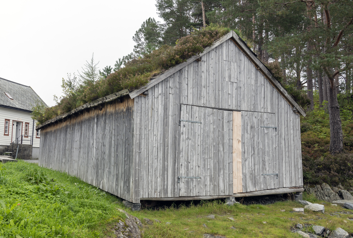 Grindbygg med ståande låvepanel og torvtak.