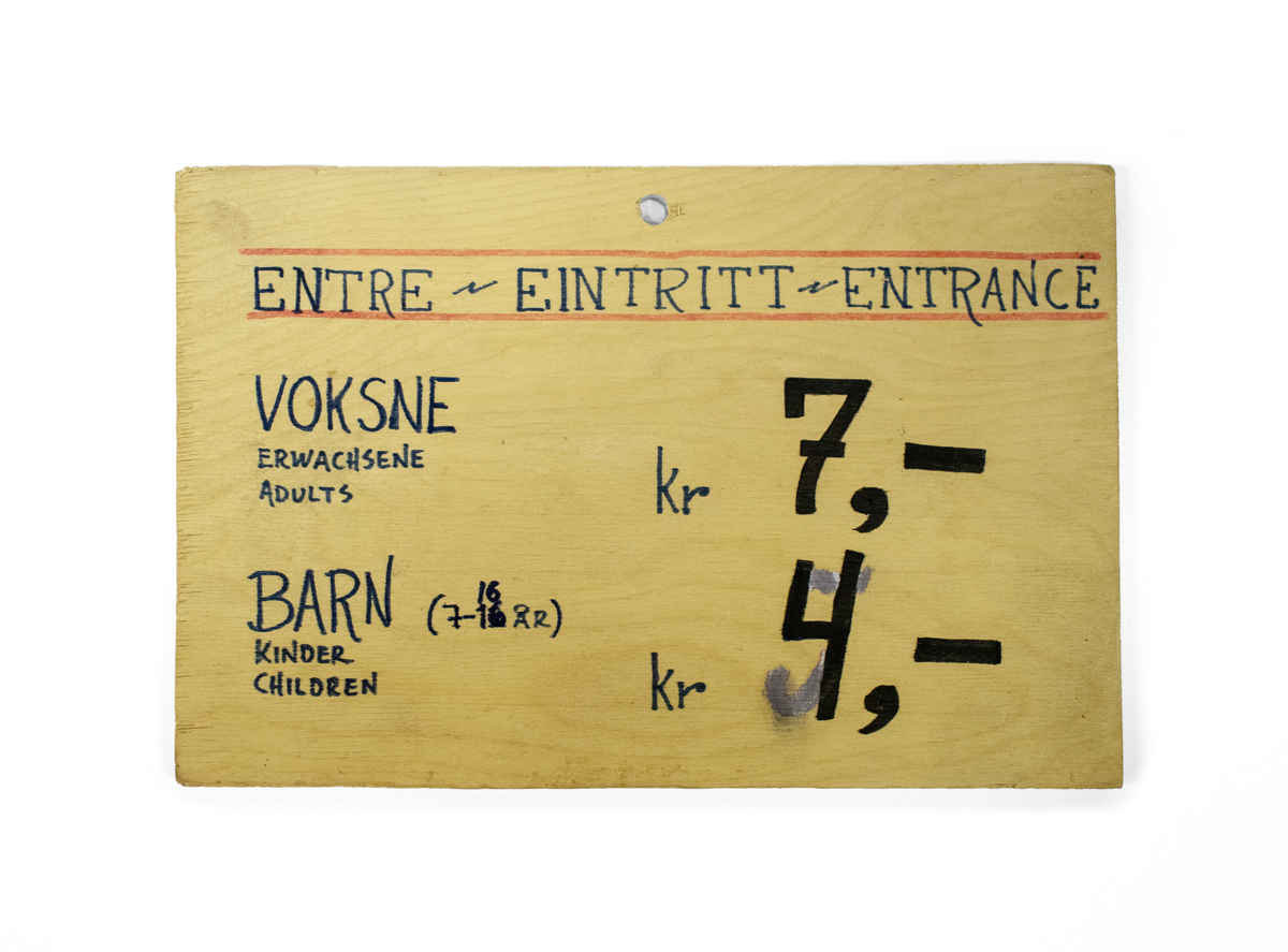 Inngangsskilt med prisliste. Skrevet med tusj på treplate.