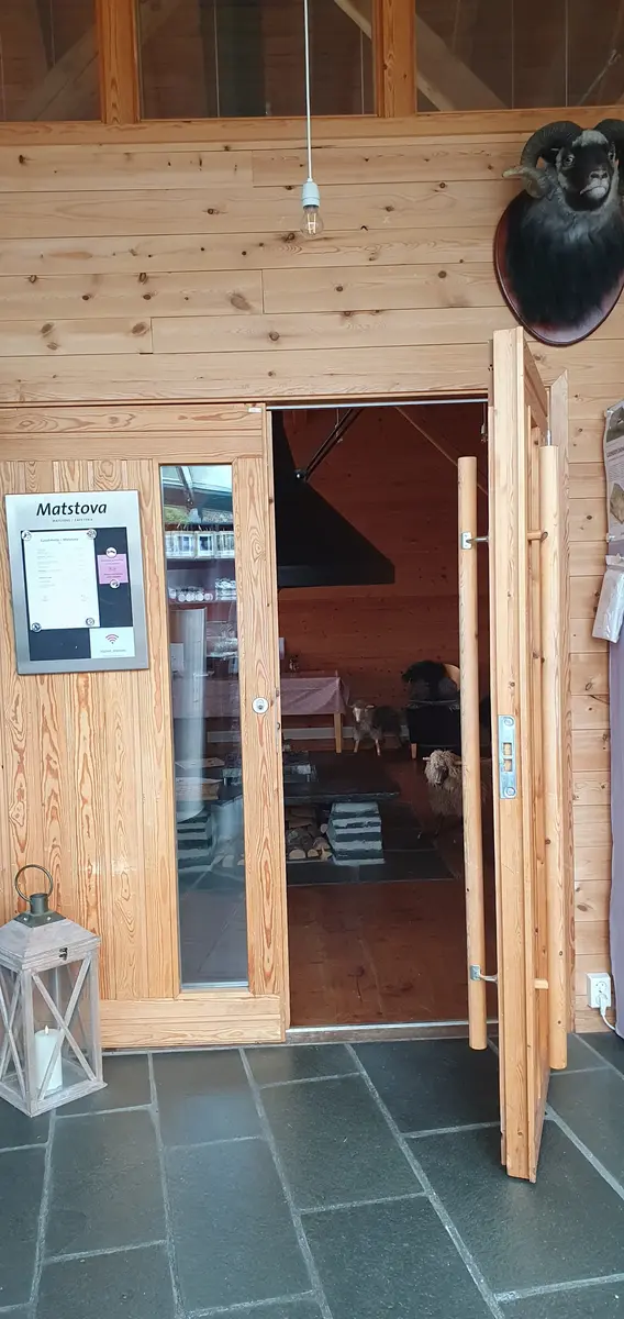 Dør frå butikk og resepsjon inn til kafé Matstova. Dobbeldør med eine døra open.