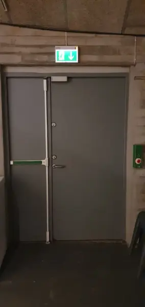 Grå dobbeldør i metall som er naudutgangsdør frå utstillingsrommet