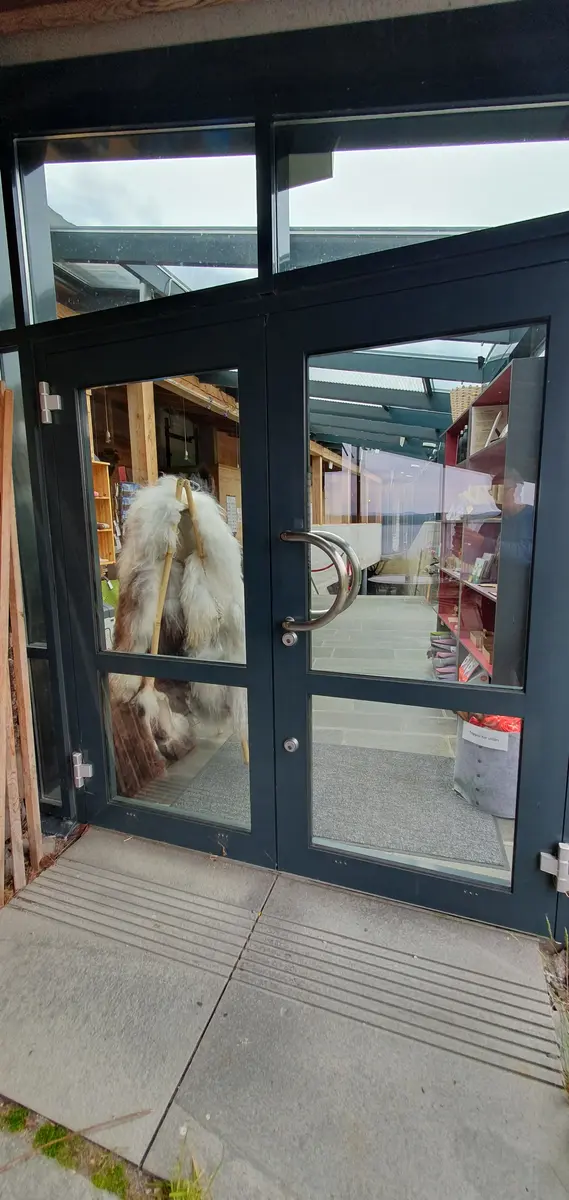 Sideinngang til museumsbutikk og resepsjon. Dobbeldør i glas og metall, 180 cm brei.