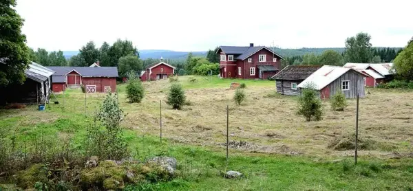 Gårdstun med eldre, rødmalte bygninger.