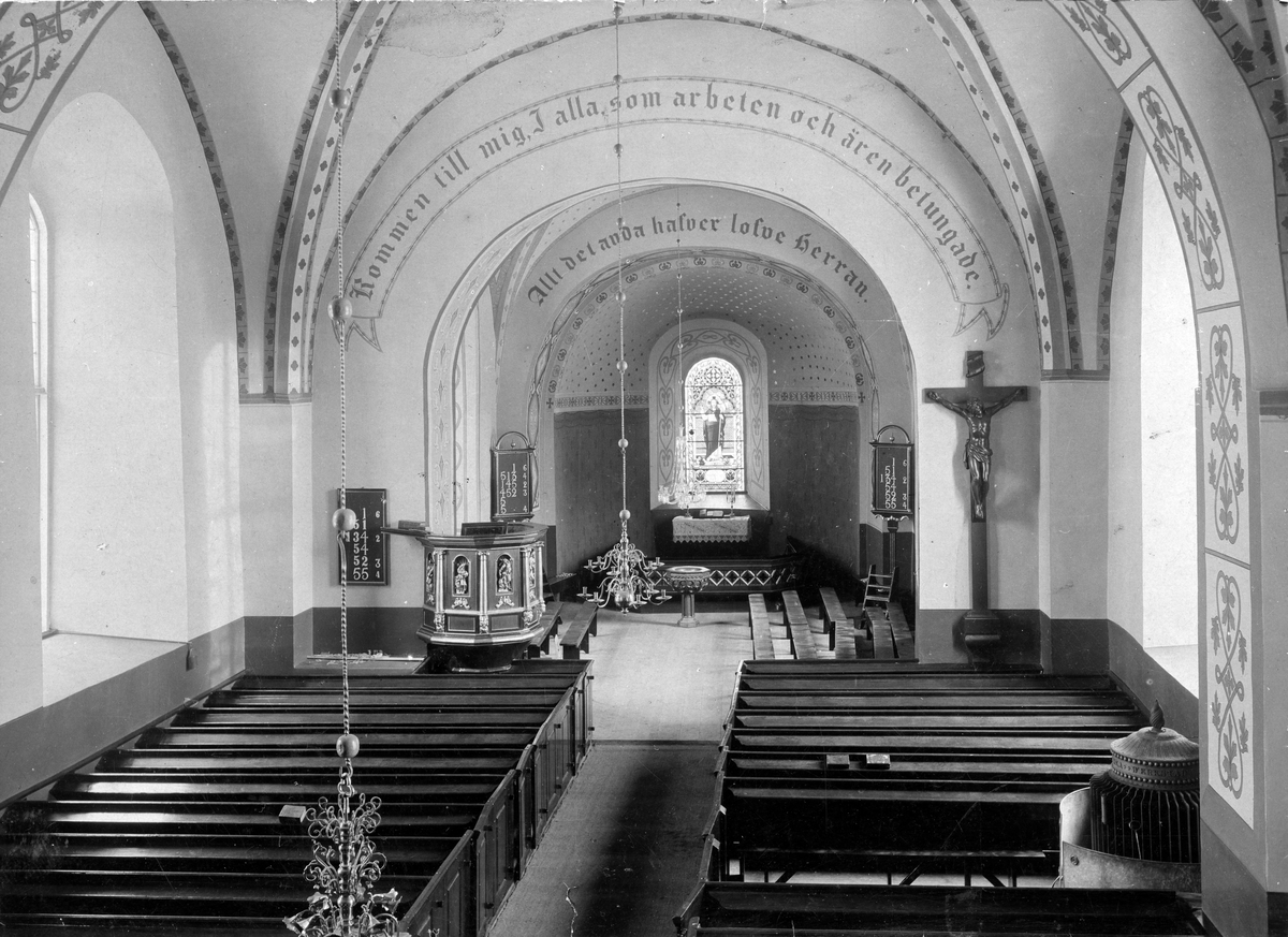 Interiör av Falköpings kyrka före restureringen 1899*, innan centralvärmen infördes Predikstolen flyttades då åt höger och även krucifixet. (* = Oklart, även årtalet 1926 nämns på ett liknande foto).