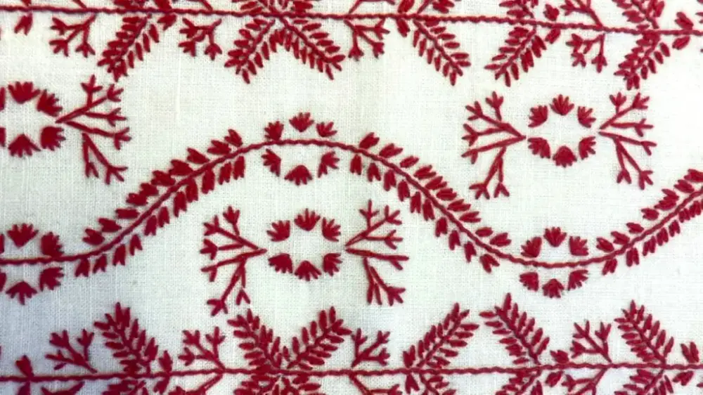 Rött broderi på vitt tyg