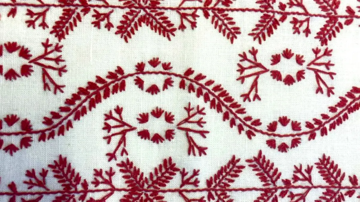 Rött broderi på vitt tyg