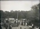 En mängd människor strosar runt i Societetsparken mellan olika slags marknadsstånd.  Barnens Dag (?). 
Delvis suddigt foto.