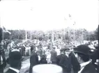 Foto av en folksamling i Societetsparken, Varberg. Trol. från
midsommarfirande, eller Barnens Dags-firande.