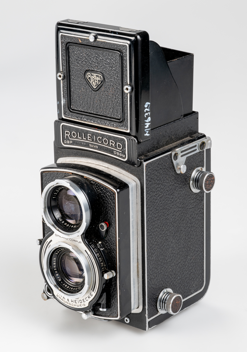 Rullfilmskamera av tyskt fabrikat, Franke & Heidecke Baunschweig, varumärke Rolliecord. Tillverkad ca 1950. Tvåögd spegelreflexkamera. Tillverkad av plåt med rattar och reglage av aluminium. Format på negativen 6 x 6 cm. Tillhörande väska av läder. 

Använd på Smålands museum för dokumnationsfotografering av landsantikvarie och dåvarande museichef Jan-Erik Anderbjörk mellan ca 1950-1965.