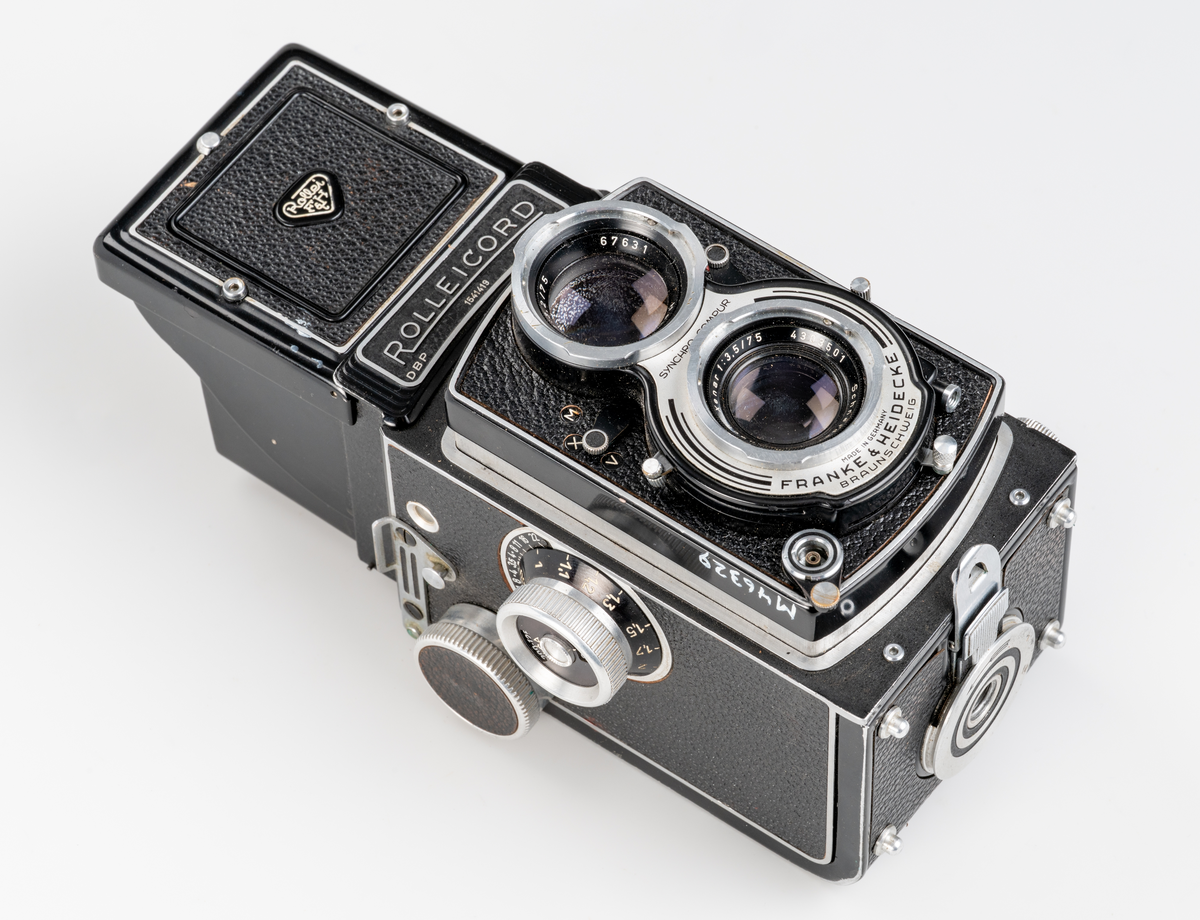 Rullfilmskamera av tyskt fabrikat, Franke & Heidecke Baunschweig, varumärke Rolliecord. Tillverkad ca 1950. Tvåögd spegelreflexkamera. Tillverkad av plåt med rattar och reglage av aluminium. Format på negativen 6 x 6 cm. Tillhörande väska av läder. 

Använd på Smålands museum för dokumnationsfotografering av landsantikvarie och dåvarande museichef Jan-Erik Anderbjörk mellan ca 1950-1965.