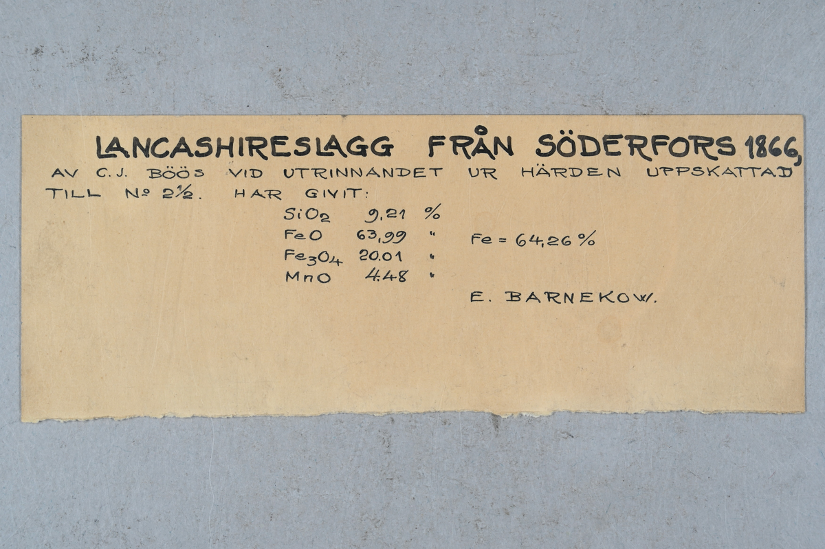 13 prover på lancashireslagg. Tillhörande lapp med notering: "Lancashireslagg från Söderfors 1866, av C. J. Böös vid utrinnandet ur härden uppskattad till No 2 1/2. E. Barnekow."