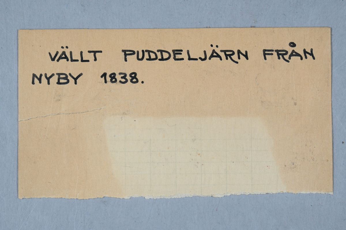 Två prover på puddeljärn. Tillhörande lapp med notering: "Vällt puddeljärn från Nyby 1838."