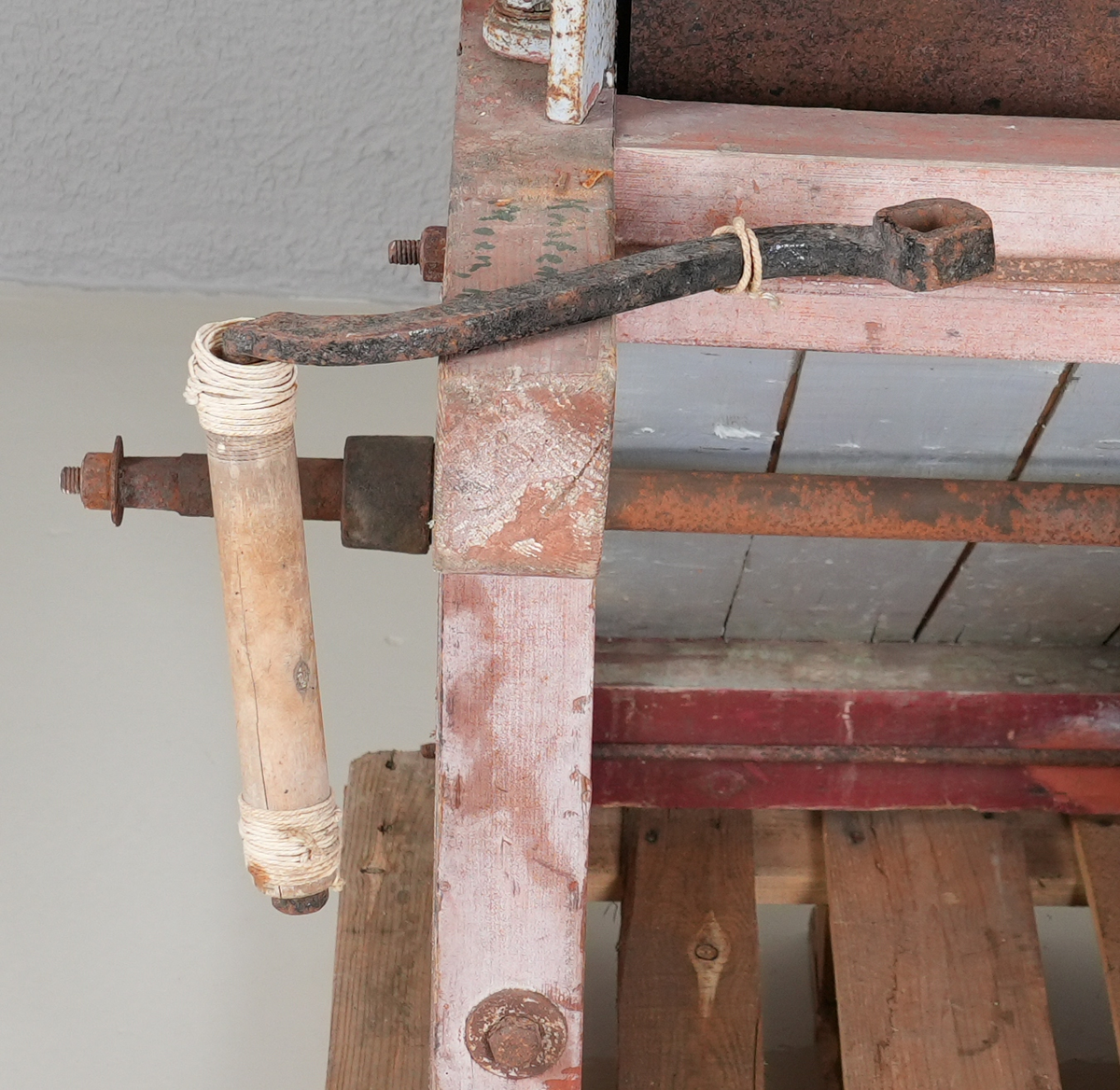 Piggtreskemaskin. Kontruksjon (stativ) i tre rundt maskina. 
Øvste del av maskina er i metall, medan nedste (renne) er i tre. Maskina har opning oppe på eine kortsida, der det er monternt ein metall sylinder med piggar (på aksling). Under metall sylindaren er det ei trerenne som skrånar nedover. 
På eine sida av stativet er det montert fleire tannhjul som grip i kvarandre. Stort hjul i tre ytst. Feste for sveiv stikk ut på andre sida. 
Sveiva driv hjulet via aksling under tre-renna, og via tannhjule vil den pigga metallsylinderen dreie rundt.
Treråma er raudlilla med kvit og svart stripe. Maskina er turkis med gule kantar og raud skrift på sidene.