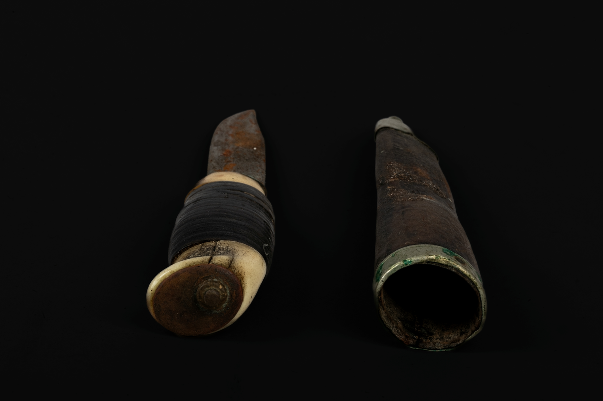 Kniv og slire. Kniven har skaft i bein som er slipt glatt. Rundt skaftet er det trukket skinn. Skinnet er surret rundt skaftet. Sliren består av metall (sølv) og skinn. På skinnet vises konturer av tidligere dekoreringsarbeid. Sømmen bak sliren er meget tett, bein og jevnt sydd. På slirens inngangsparti er det lagd et sølvbeslag som fungerer som en slags falsavslutning. Denne har dekor i form av to streker som går parallelet med lengdretningen av beslaget, altså på tvers av sliren. Den ene streken er nesten slitt bort. 
I tuppen av sliren er det festet et beslag av metall eller sølv. Dette er avsluttet med en liten kule, som utgjør tuppen av sliren.  Kniv og slire er forseggjort og er et pent arbeid.