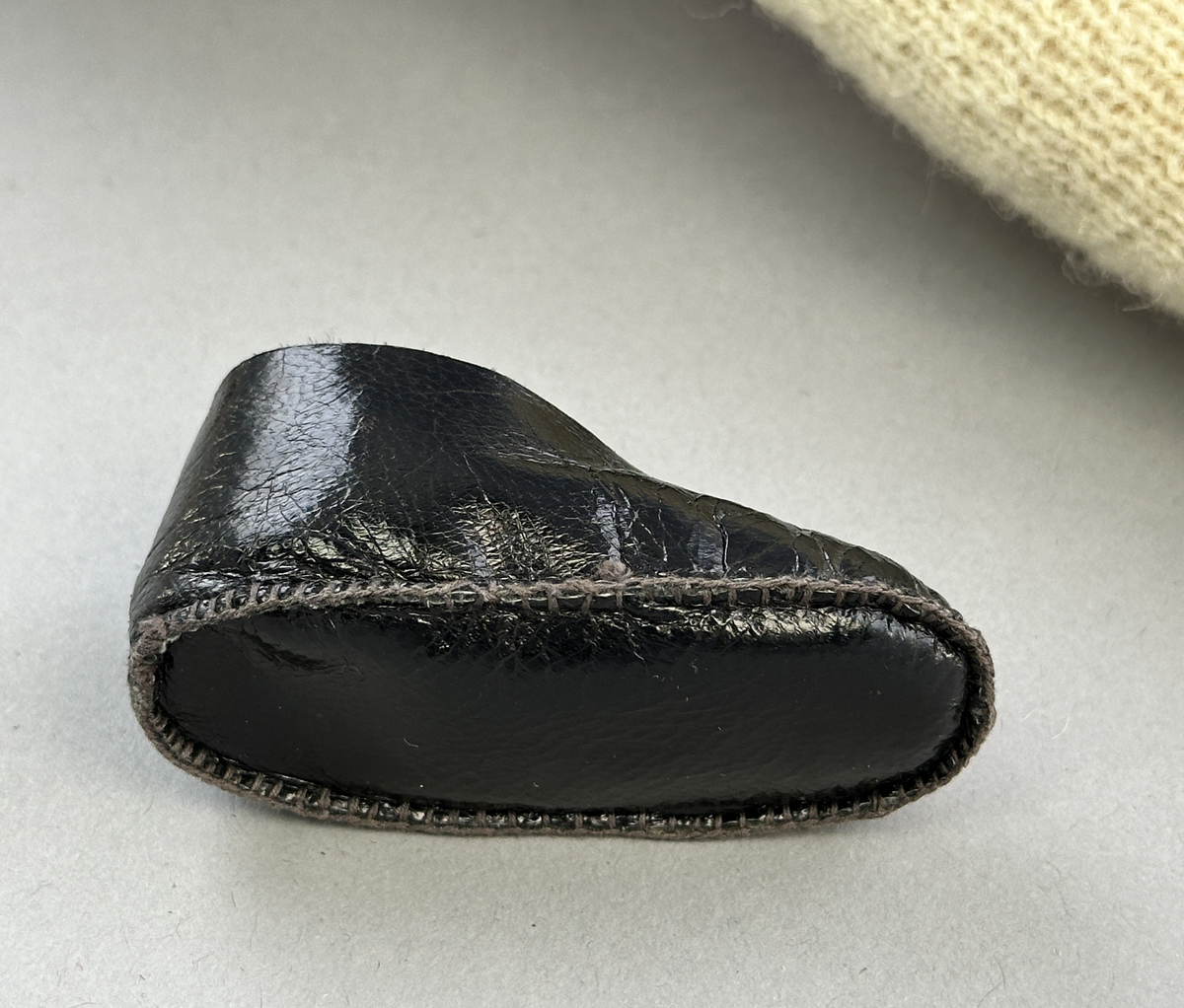 Docka klädd i kvinnlig sockendräkt från Dalby socken i Värmland. Kroppen är handsydd i linnetyg och stoppad med textilt material. Huvud och händer är av lergods. Kläder handsydda av handvävda tyger förutom skjorta, underkjol och halskläde, som är maskinvävt. Skjortan består av halsspjäll, krage och handlinning med stripade veck runt  krage och manschett. Skjortan är broderad med rutsöm vid sprund, krage, axelsöm och handlinning. Knytband bestående av trefläta (i rött och vitt) och tofsar (i rött, vitt och blått) pryder krage och manschett. Livkjol sydd med lagda veck runtom, utom under förkläde, har hals- och ärmhål kantad med passpoaler. Tyg till livkjol är vävt med bomullsvarp och ullinslag. Livet på livkjolen är vändsytt/fodrat med ett linnetyg och knäpps med 3 hyskar & hakar. Livkjolen är också dekorerad med en tre-fläta av rött ullgarn i nederkant. Även förklädet har lagda veck vid midja fastsydda mot en linning av bomullsband. Ullstrumporna är handstickade i slätstickning med en kant upptill i 2-2 resår samt en rad med avigmaskor, som "söm"-dekor på baksida ben. Huvudet är prytt med en vit linnehätta kantad med en knypplad linnespets samt ett broderi i blått och rött. Dockans fötter bär svarta skinnskor.

