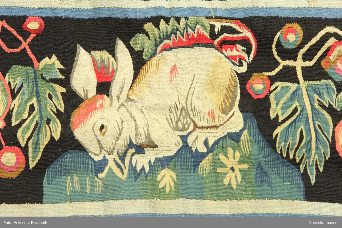 Huvudliggaren:
"Vävd tapet från 1700-talets början. Enligt uppgift från Skåne. Framställer varjehanda blommor strödda mot svart grund."
