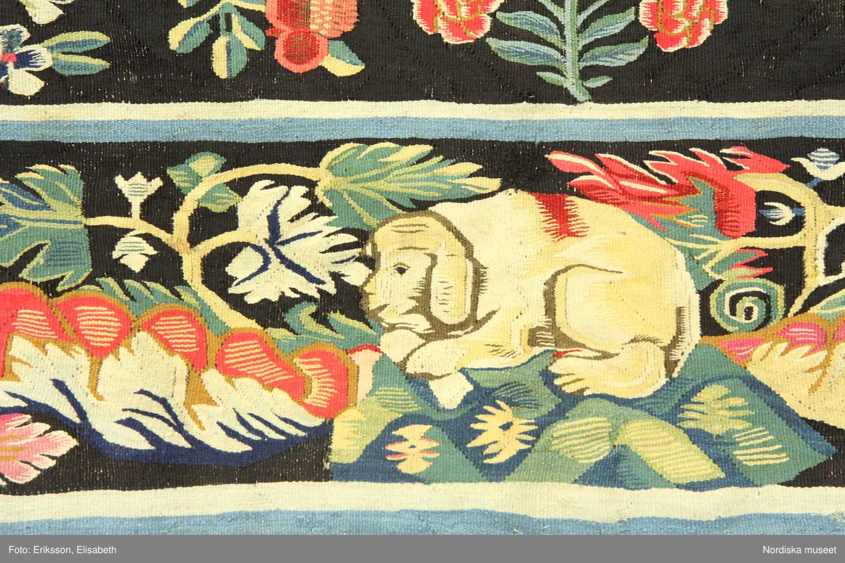 Huvudliggaren:
"Vävd tapet från 1700-talets början. Enligt uppgift från Skåne. Framställer varjehanda blommor strödda mot svart grund."
