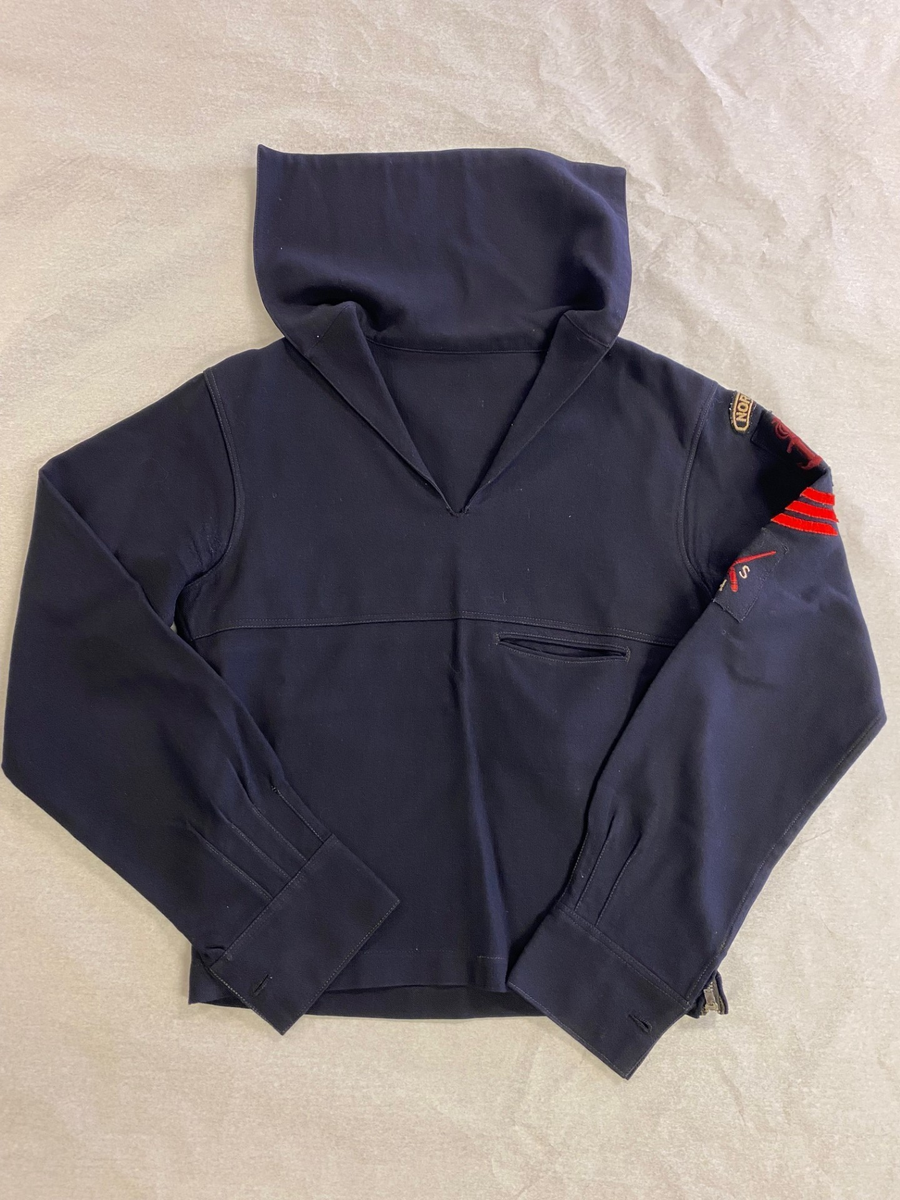 1 stk. jumper påsydd merkene "Norway", "Sjøforsvarets merke", "tre røde vinkler i filt for ansinnitet", "SSH" (sjøforsvarets skytteravdeling for handelsflåten), som del av uniform til Sjøforsvarets Skytteravdeling for Handelsflåten under 2. verdenskrig.