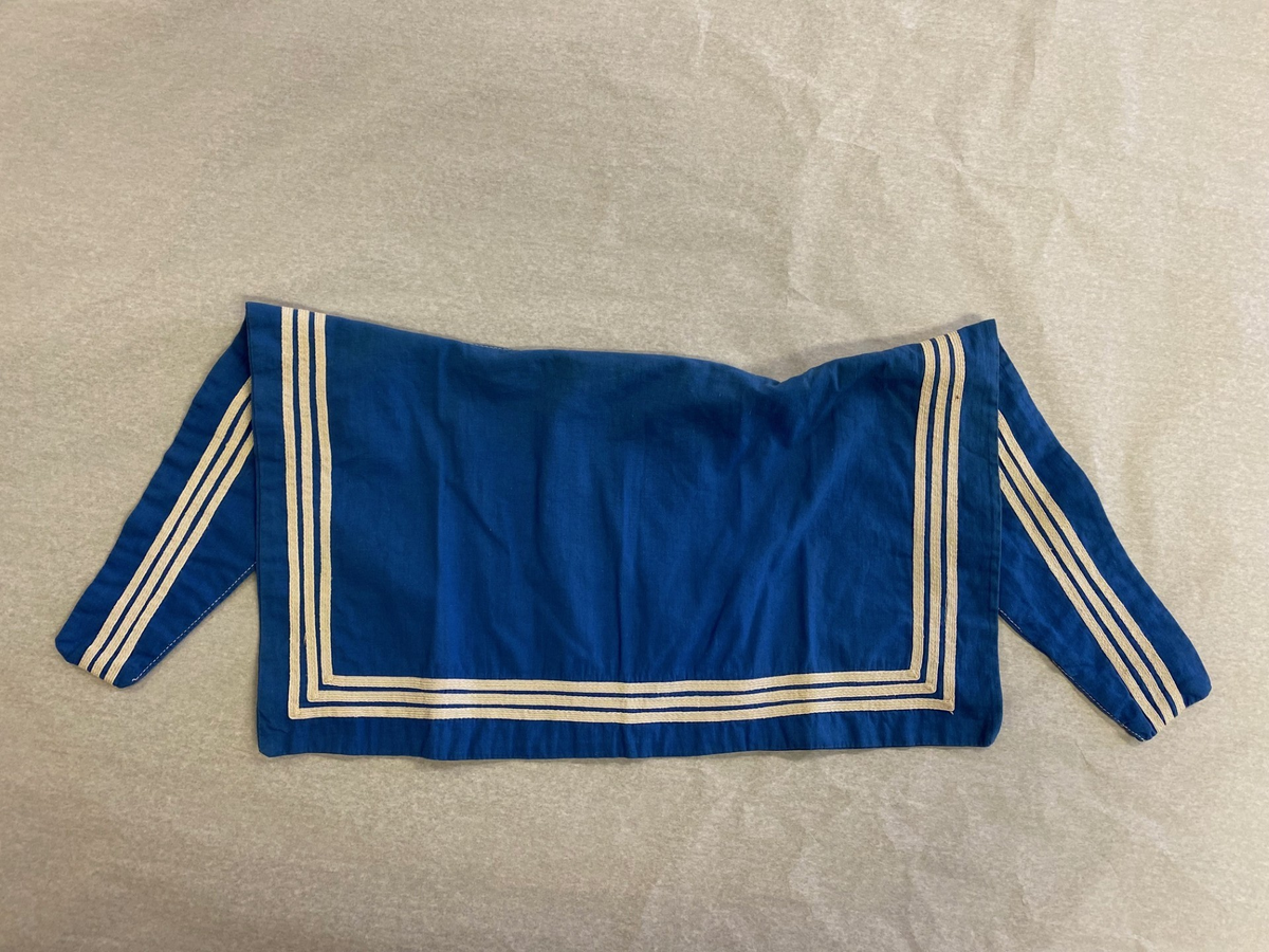 Blåkrage i hvitt og blått som festes på jumper.