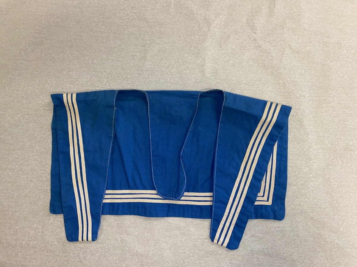 Blåkrage i hvitt og blått som festes på jumper.