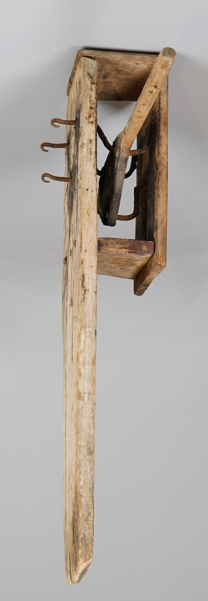 Reipslagarutstyr. Ei trefjøl med "kasse" i tre på eine sida (pluggar av tre). Inni kassa er det tre bøygde jarnstenger som er trædd gjennom tre hol i ei trefjøl. Denne trefjøla stikk ut frå "kassa"med eit handtak. Jarnstengane stikk ut gjennom tre hol på kvar side, eine sida som rette tappar, på andre sida (den lange fjøla), som krokar.